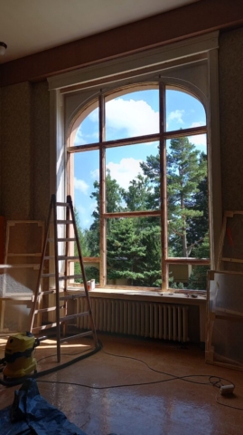 Práce prebiehajúce počas renovácie povrchovej úpravy na drevených oknách.